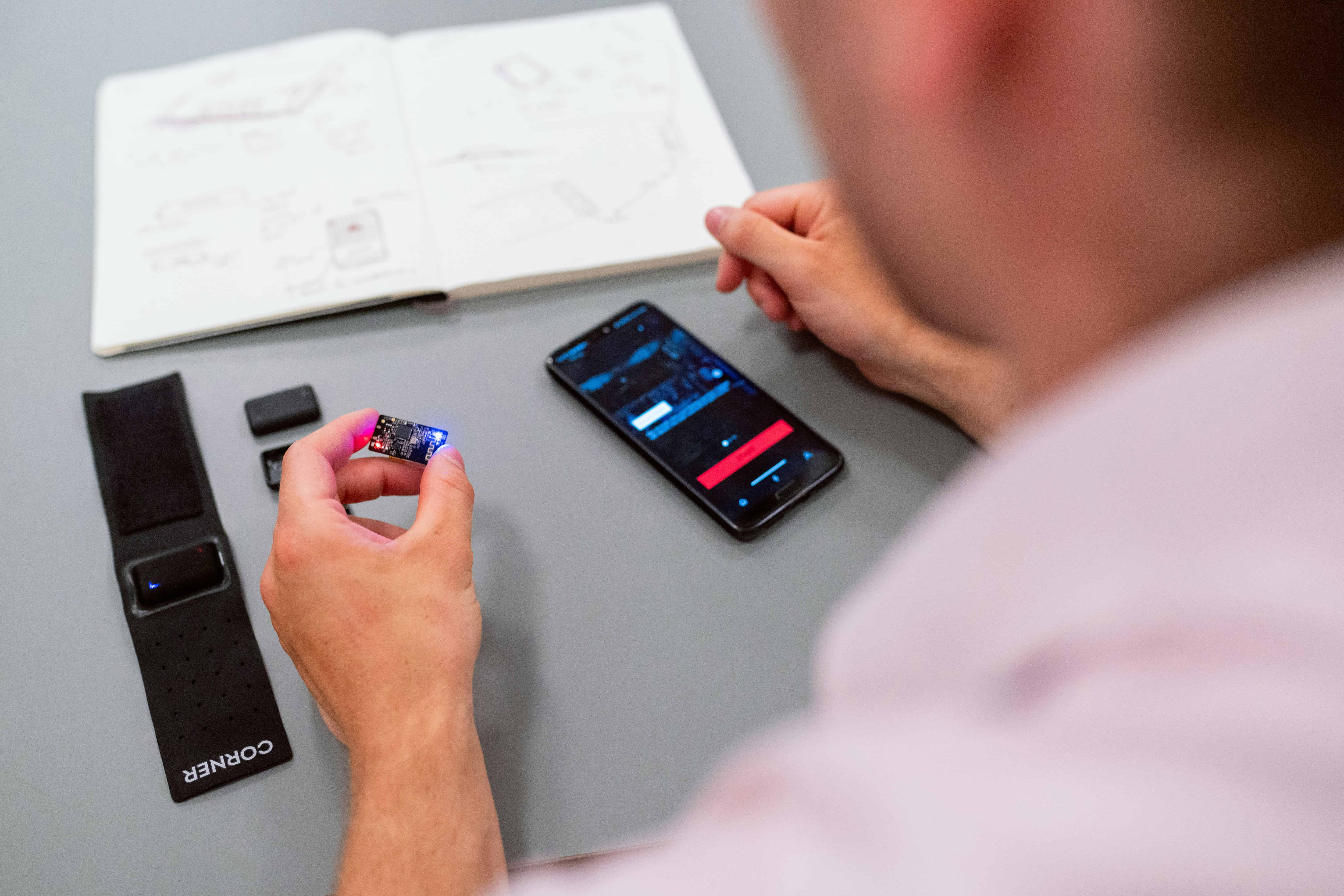 A man with a mobile phone and a computer chip in his hands is testing an application.