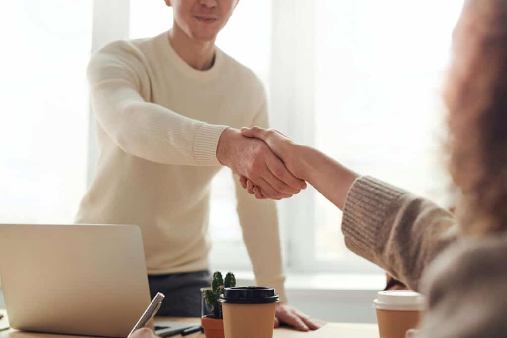 Two people in an office are making an agreement and shaking hands.
