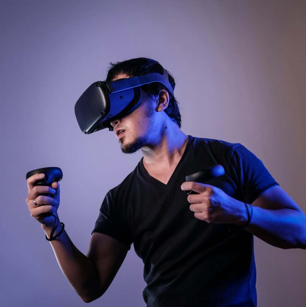 A man wearing VR goggles and holding two controllers.