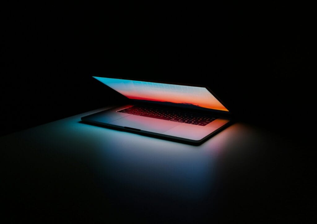 A dark room with a half-open laptop.